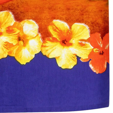 Detalle: flores amarillas en el bajo de una camisa violeta de manga corta