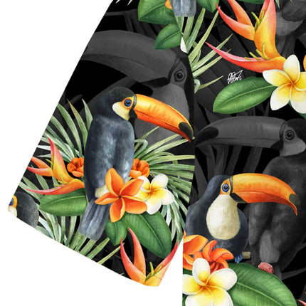 Dettaglio del tessuto con tucani su fondo nero, circondati da foglie di palma verdi e fiori